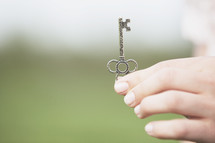 Hand holding silver key.