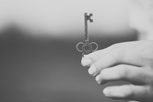 Hand holding a silver key.