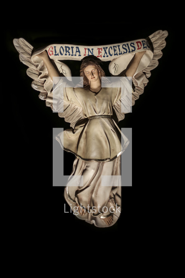 Angel figurine holding a banner reading Gloria in Excelsis