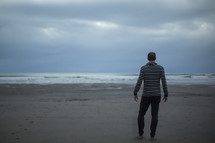 man standing alone on a beach 