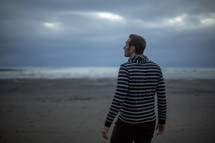 man standing on a beach alone 