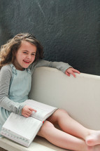 Happy girl reading her Bible on a bench.  