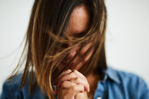 a woman with head bowed in prayer 