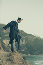 graduate stepping off a cliff