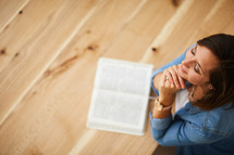a woman praying and an open Bible 