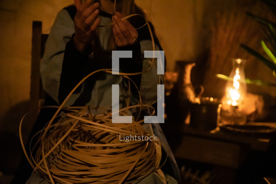 weaving a basket in candlelight 