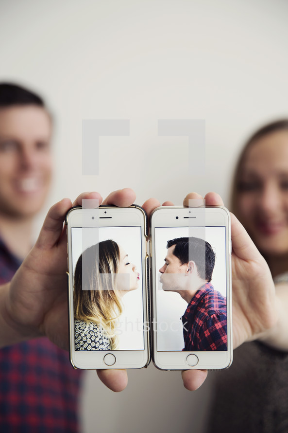 kissing couple on cellphone screens