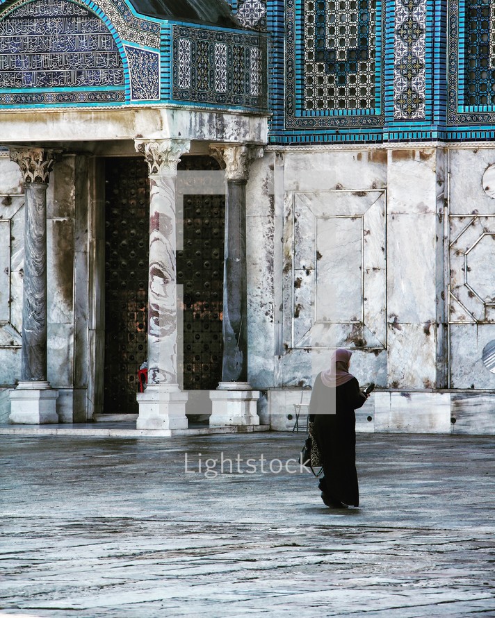 muslim woman standing in front of a mosque 