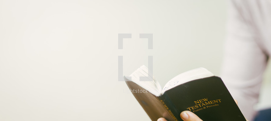 person reading a pocket Bible - New Testament