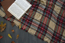 open Bible on a plaid blanket 