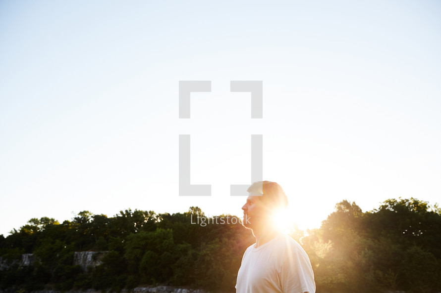 a man standing outdoors and a sunburst 