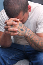 tattooed hands in prayer
