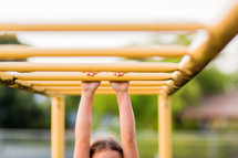 Child, young girl, hanging from bars, playground, hang in there, hold tight, grasp, play, monkey bars