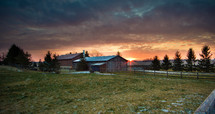 sunset over a red barn