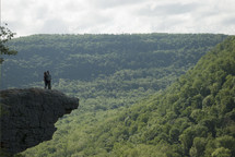couple standing on the edge of a mountain 