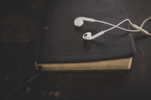 White ear buds on a Bible