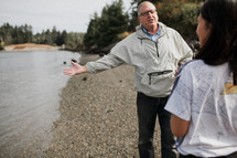 a pastor talking with a woman before a river baptism 
