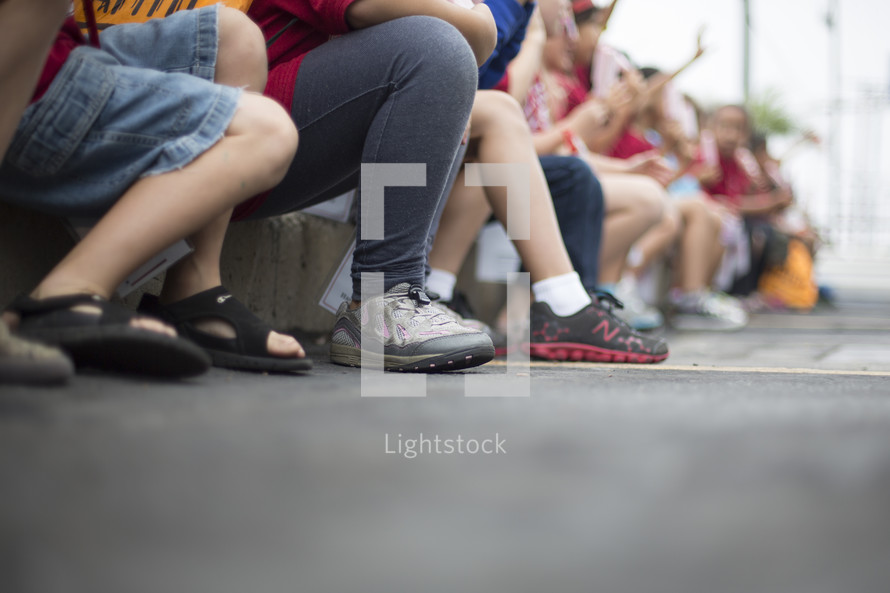 children sitting on the curb 
