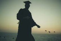 silhouette of a graduate on a beach