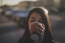 A woman drinking a cup of coffee 