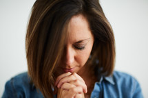 a woman with head bowed in prayer 