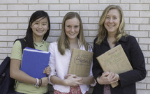 Smiling teens with text books at school.
