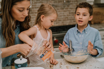 a mother baking cookies with her children 