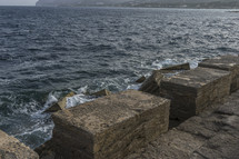 Huge breakwater stones, Mediterranean sea crashing against the rocks of the Spanish island of Mallorca, Ibiza, Spain.