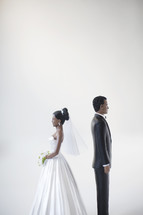 bride and groom figurines standing back to back 