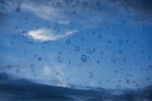 water spots on a camera lens , soap bubbles against blue sky