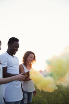man and woman holding colorful smoke flares 