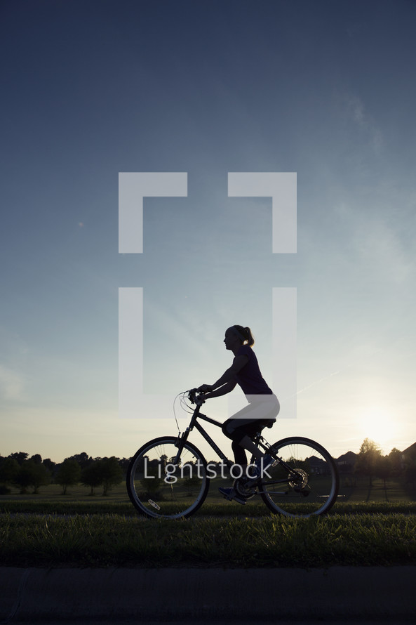 woman riding a bike at sunset 
