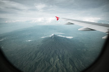 wing of a plane flying over mountains 