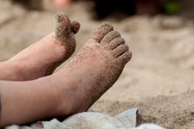 child's feet in the sand 