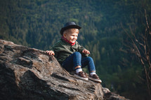 Cute Little Smiling Happy Boy with Hat and Bandana in Rocky Mountains