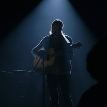 man playing a guitar on stage 