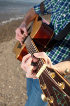 torso of a man playing a guitar