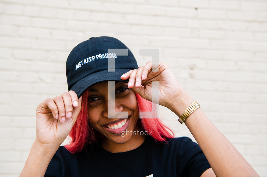 portrait of a young African American woman with Just Keep Praising Hat 