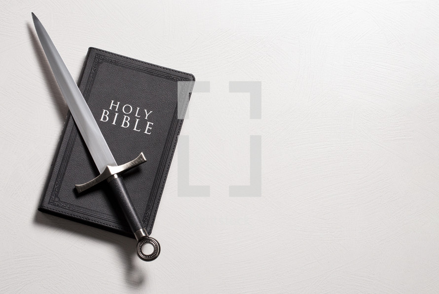 A Bible and Sword on a Bright White Background