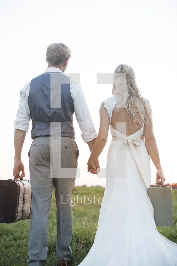 bride and groom carrying luggage 