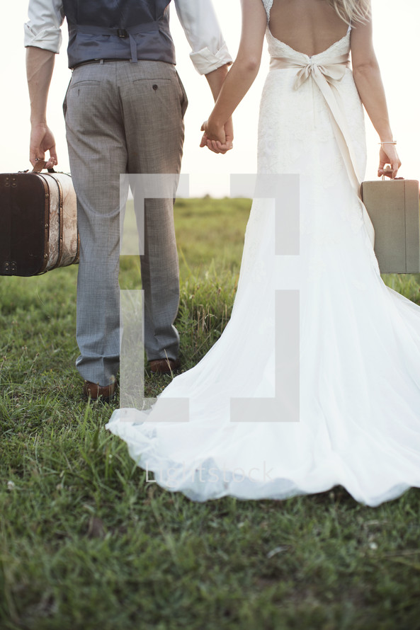 bride and groom carrying luggage 