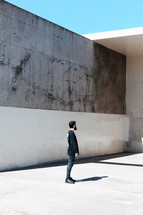 a man standing in front of a concrete wall 