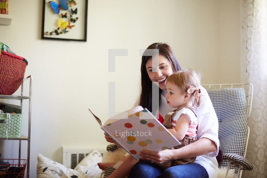 a mother reading a book to her daughter 
