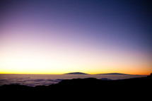 horizon over mountaintops in the clouds at dawn 