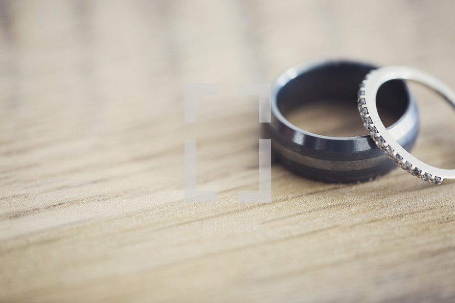 wedding bands on a wooden table top. 