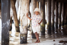 boy child standing under a pier 