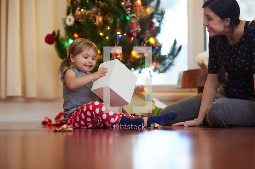 a mother giving her daughter a present to open at Christmas 