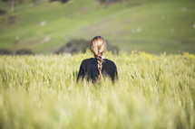 a woman standing in a field of wheat 