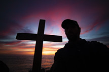 silhouette of a man and cross at sunset 