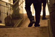 a man's feet walking down a sidewalk 